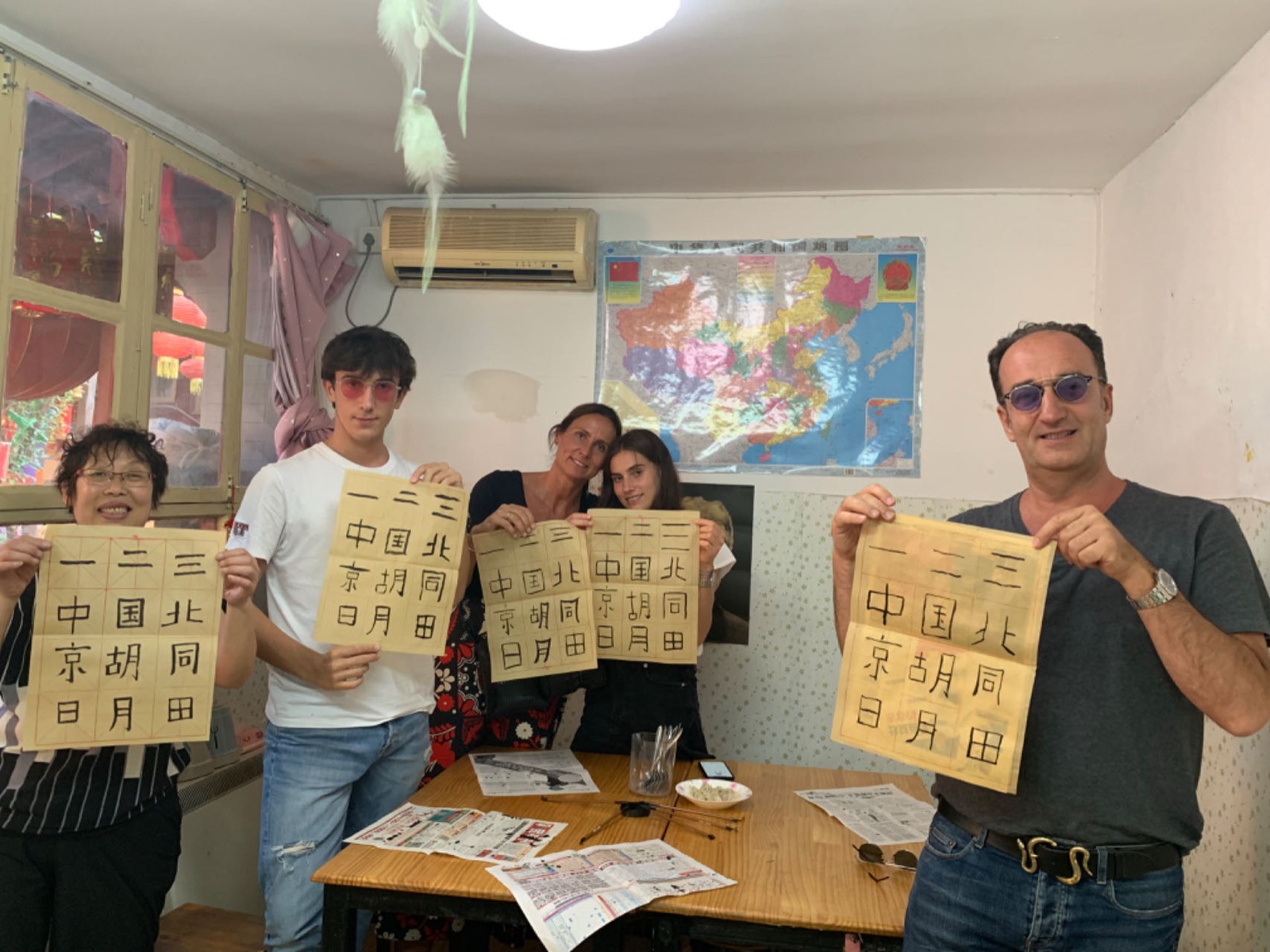 Guests holding calligraphy work during a Beijing cultural workshop